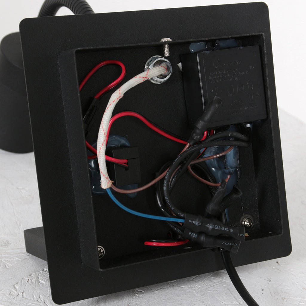 Wandleuchte aus schwarzem Metall mit kabellosem Ladepad und USB-Anschlüssen
