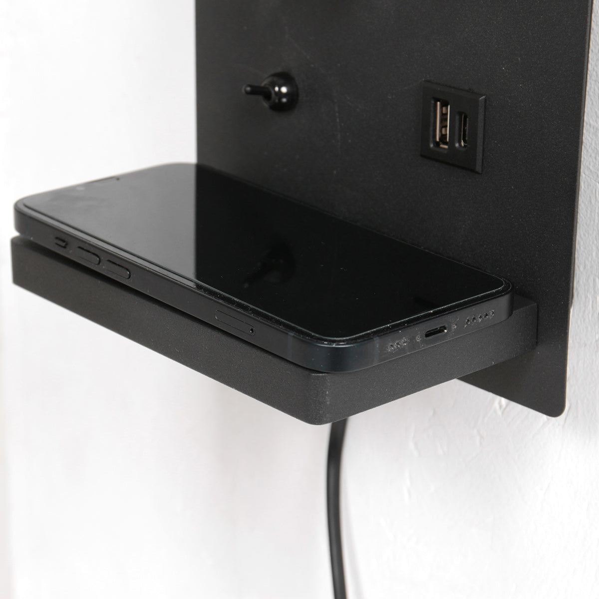 Wandleuchte aus schwarzem Metall mit kabellosem Ladepad und USB-Anschlüssen