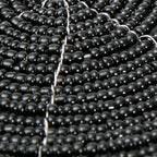 Runder Glasuntersetzer aus schwarzen Perlen mit Spiralmuster