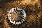 Runder Untersetzer aus Rattan in Braun mit weißem Muschelrand