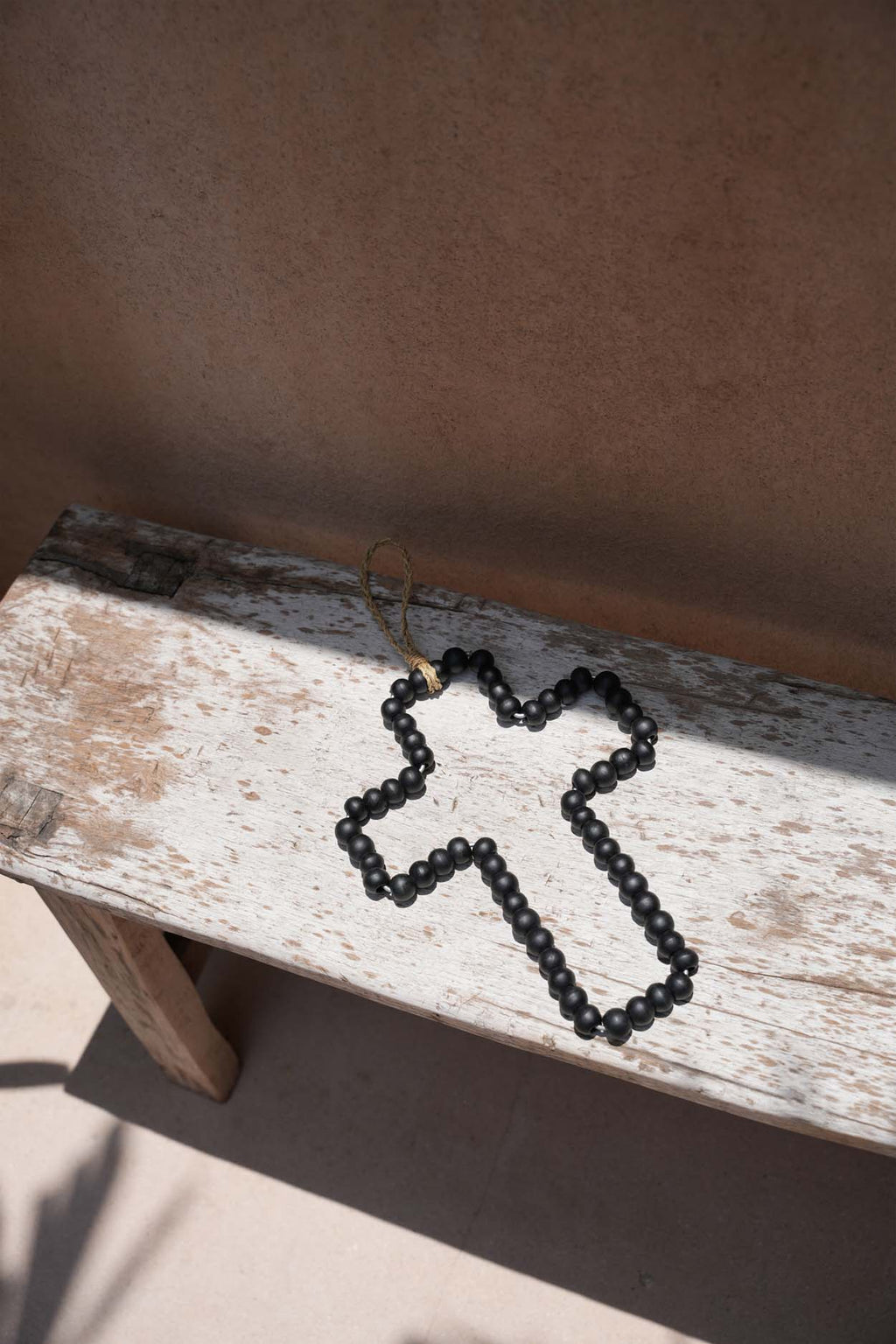 Deko-Wandkreuz aus schwarzen Holzperlen mit Jutekordel