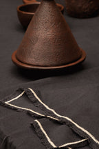 Leinenserviette in Schwarz mit Fransen und ecrufarbener Bordüre