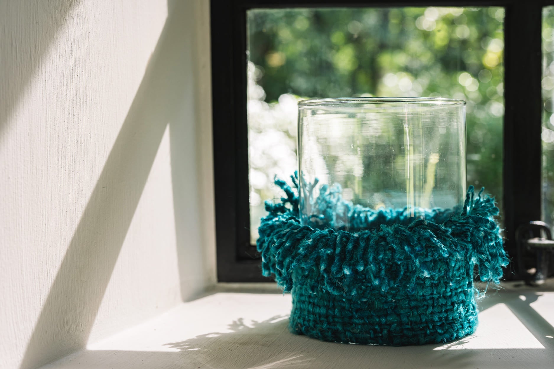 Windlicht aus Glas mit türkisem Webbezug und Fransen – Höhe 15 cm