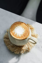 Becher aus Keramik in Creme mit breitem Henkel und braunem Rand