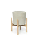 Cache-pot en terre cuite et teck avec un planteur cylindrique gris clair sur support en bois naturel