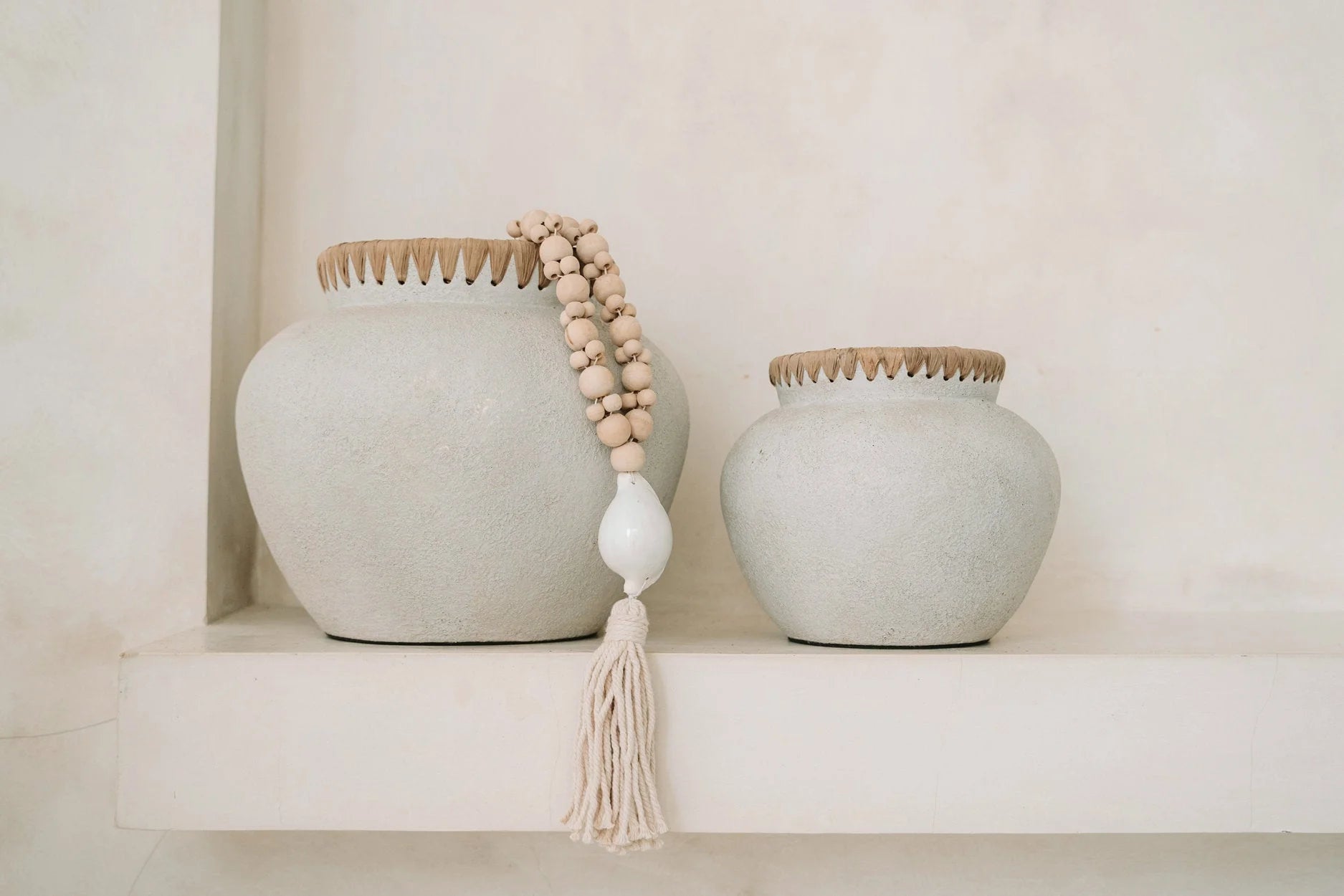 Vase en céramique blanche avec bord en bois, accents coquillages et perles naturelles