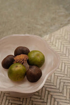 Coupe décorative en résine rose marbrée sur pied avec fruits tropicaux