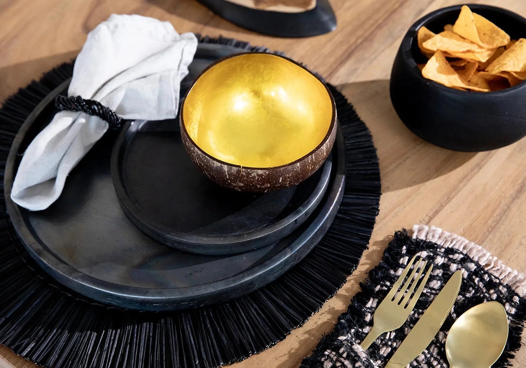 Assiette en terre cuite noire brûlée 30 cm avec place setting nappe blanche et or