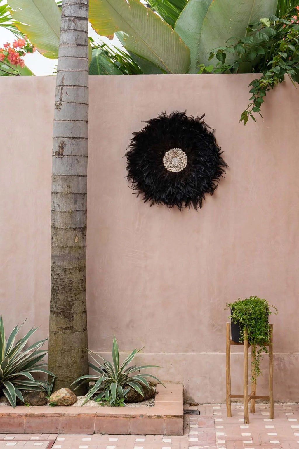Juju hat rond en plumes noires avec centre tissé et coquillages décoration murale