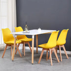 Lot de 6 chaises scandinaves jaunes autour d’une table blanche dans une salle à manger