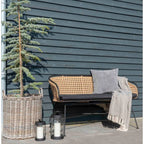 Banc en rotin tressé avec cadre métal noir et coussin foncé