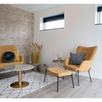 Fauteuil beige rembourré à pieds noirs avec pouf assorti