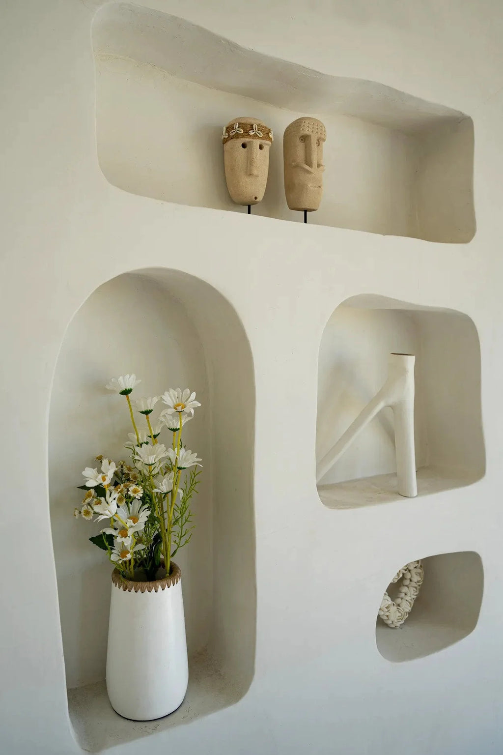 Mur blanc avec niches décoratives en Pierre de Sumba en grès beige sculptée à la main