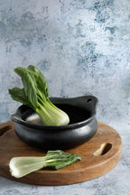 Bok choy frais dans un plateau rond en racine de teck naturel avec poignées Ø40 cm