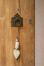 Poignée de porte en métal ornée d’une feuille décorative et d’une perle à pompon
