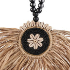 Pompon mural en raphia noir et naturel avec perles et fleur centrale