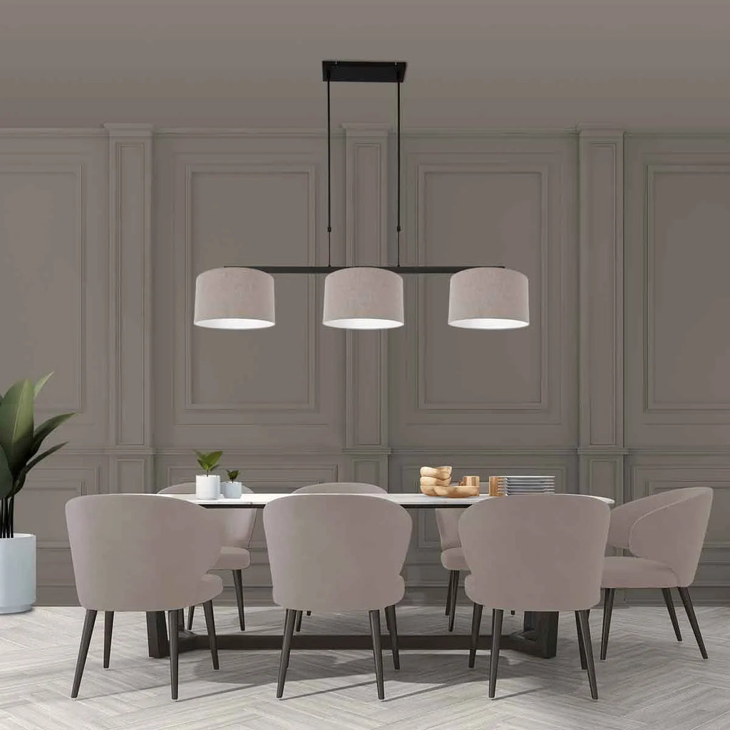 Suspension linéaire en métal noir avec trois abat-jours en tissu taupe dans une salle à manger moderne