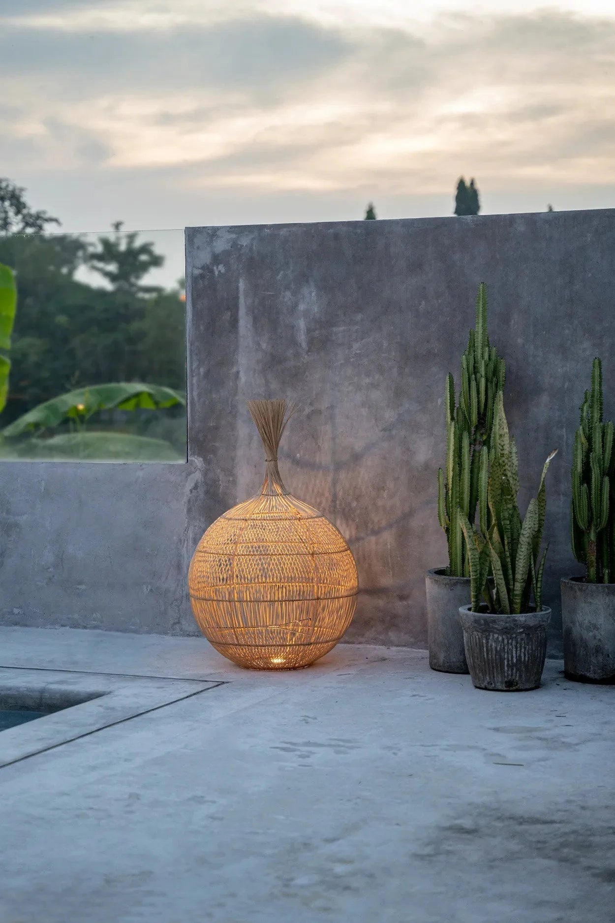 Suspension ovale en rotin naturel ajouré avec lampe sphérique extérieure à l’intérieur