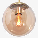 Suspension en verre ambre et métal doré sphérique avec ampoule à filament exposé